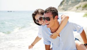 young couple at the beach in sunglasses