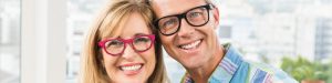 mature couple in glasses smiling